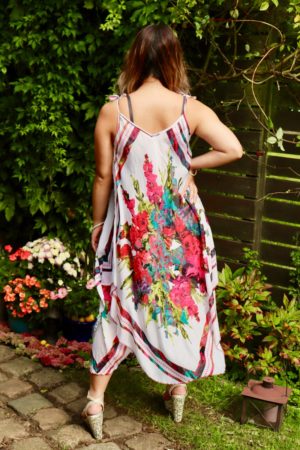 The back of a white floral dress with red and blue floral prints. Asymmetrical cutting in 2 layers.
