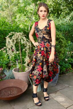 Smart sort kjole med blomster i røde, hvide og olivengrønne nuancer. Dyb halsudskæring, ballon formet og store funktionelle lommer